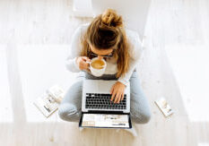 women sipping tea and working on computer